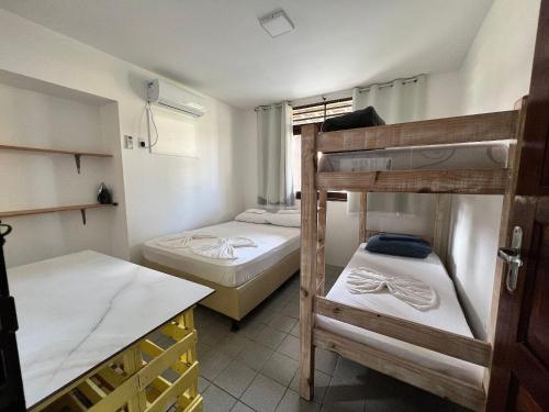 马拉戈日Chalés Praias Brasileiras的客房设有两张双层床和一张桌子。
