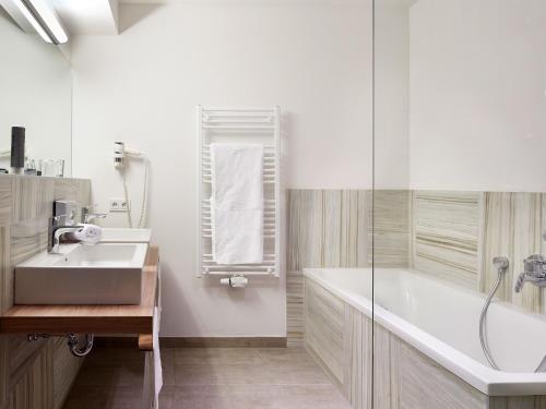 皮森多夫梭尼奥尔皮恩度假酒店的带浴缸、水槽和淋浴的浴室