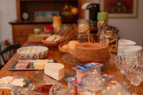 欧鲁普雷图Pouso Jardim de Assis的一张带奶酪的木桌,上面有蛋糕