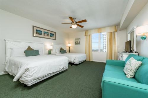 代托纳海滩Unit 2430 Ocean Walk - 2 Bedroom Ocean View的一间卧室配有两张床和蓝色的沙发