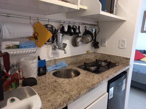 彼得罗波利斯Apartamento aconchegante em Petrópolis的厨房柜台设有水槽和炉灶。