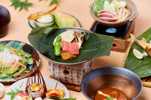 日田市Seitenkaku的餐桌,盘子上放着食物和碗
