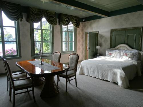 赞丹桑斯安斯风车村美好住宿的卧室配有一张床和一张桌子及椅子