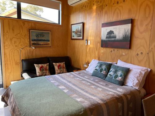 莫图伊卡Glenwai的一间卧室配有一张带木墙和窗户的床。