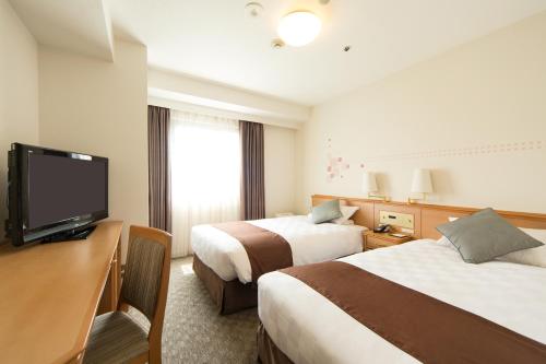 大阪大阪东急REI酒店的酒店客房设有两张床和一台平面电视。