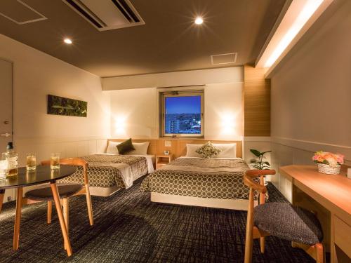 Tokai东海城市酒店的酒店客房设有两张床和一张桌子。