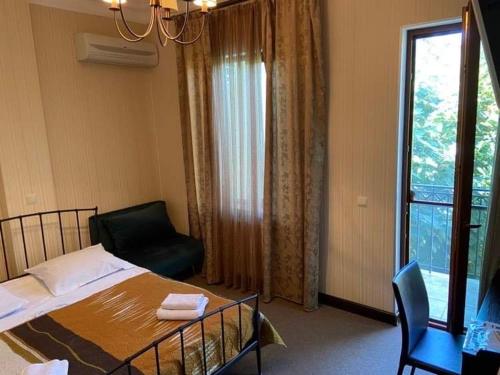 西格纳吉兹维里屋巴尼酒店的卧室配有床、椅子和窗户。