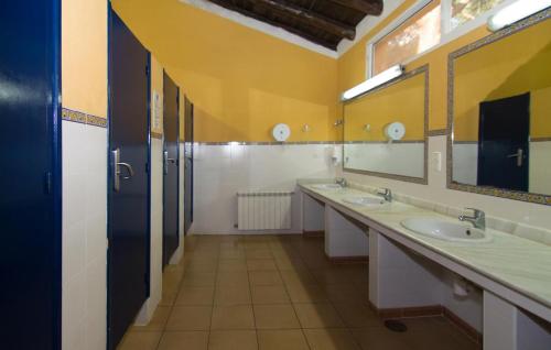 马贝拉Kampaoh Marbella的一间带三个水槽和大镜子的浴室