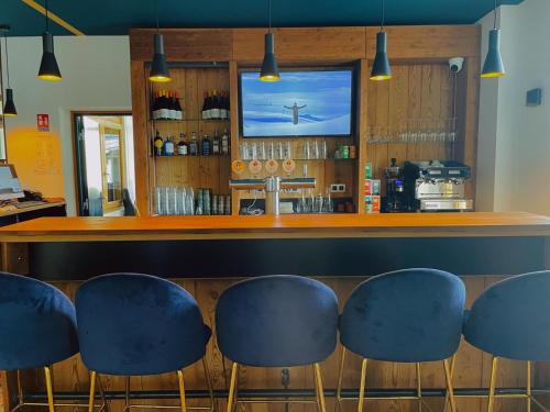 夏蒙尼-勃朗峰Hotel La Verticale的餐厅内带蓝色凳子的酒吧