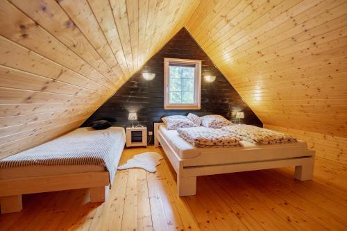 科乌切沃黑白山林小屋的阁楼上的卧室配有两张床