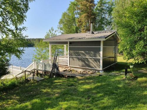 TaipalsaariMökki ja rantasauna Saimaan rannalla的湖畔码头上的小屋