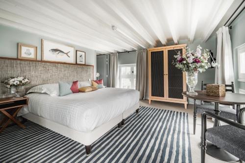 诺亚芒提亚Villa Arthus-Bertrand的卧室配有一张白色的大床和一张桌子