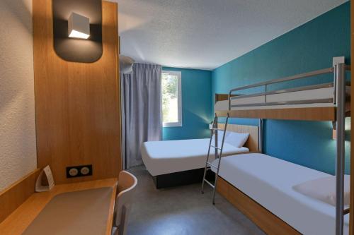 尤塞克B&B HOTEL Brive-la-Gaillarde的小房间设有两张双层床和窗户