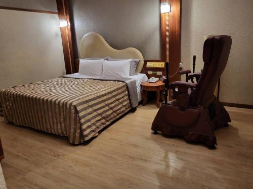 六龟Chateau Motel & Spa - Nanzi的配有一张床和一把椅子的酒店客房