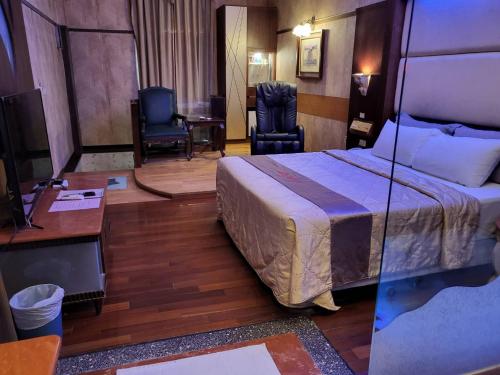 六龟Chateau Motel & Spa - Nanzi的配有一张床和一张书桌的酒店客房