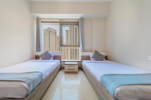 迪拜EDEN'S Homes & Villas - Sparkle Tower的带大窗户的客房内的两张床