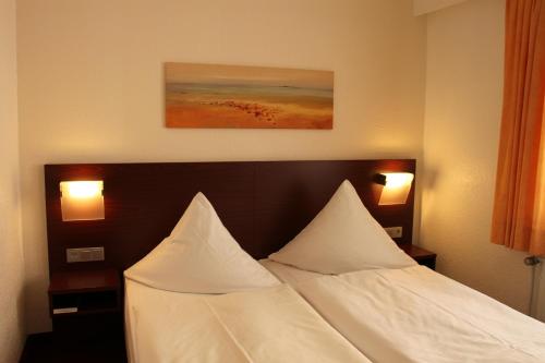汉诺威豪斯斯帕库勒伽尼酒店的一张位于酒店客房的床铺,配有两个枕头