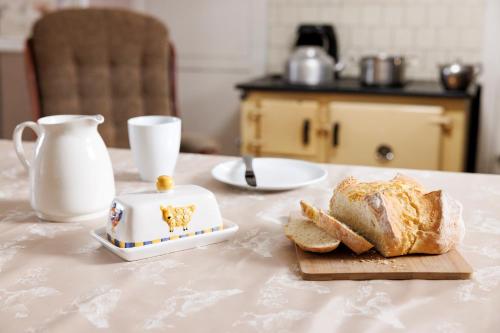 Suir Valley Cottage.的一张桌子,上面放有一盘面包和茶壶