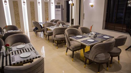 密拉特Hotel Royal 9的一间在房间内配有桌椅的餐厅