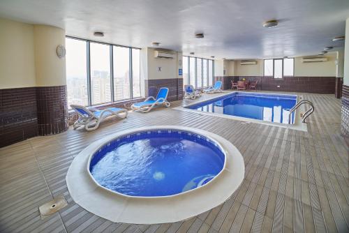 麦纳麦Vita Tower的酒店客房的大型游泳池设有大型浴缸。