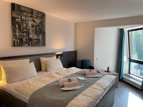 海因斯贝格克里斯顿酒店的一间卧室配有一张大床和两条毛巾