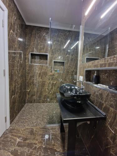 都拉斯Absolut Vollga的浴室设有黑色桌子上的黑色水槽