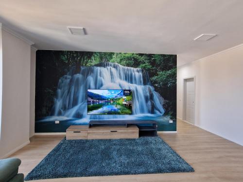 都拉斯Absolut Vollga的客厅设有电视,配有瀑布壁画