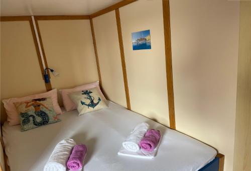 斯普利特Traditional gulet, cruises & events的床上铺有紫色和白色毛巾
