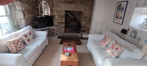 赫尔斯顿Samphire Cottage的客厅配有2张白色沙发和壁炉