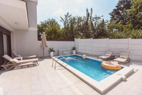 维尔蒂尼克Mi Casa 2的后院的游泳池,带椅子和庭院