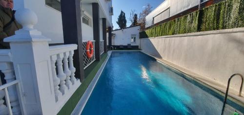 马德里Escala Suites的蓝色的建筑旁边的游泳池