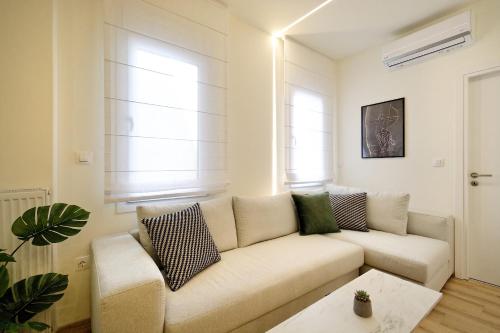 雅典Eos Residence的白色的客厅配有沙发和桌子