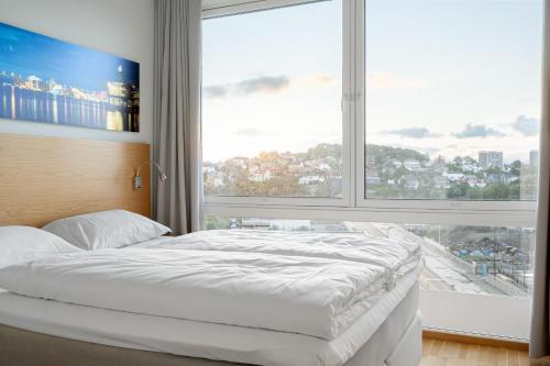 斯塔万格Frogner House - Lagårdsveien 115的一张位于带大窗户的房间内的床铺
