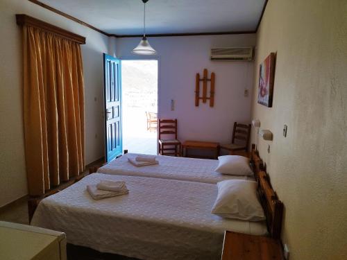 伊奥斯乔拉海神酒店的一间带两张床的卧室和一间带窗户的房间