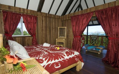 瓦尤鲁Pension Vaimano-Raivavae的卧室设有红色和白色的床和窗户。