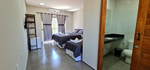 巴纳伊巴Euro Flat Hotel的一间带两张床的卧室和一间带卫生间的浴室