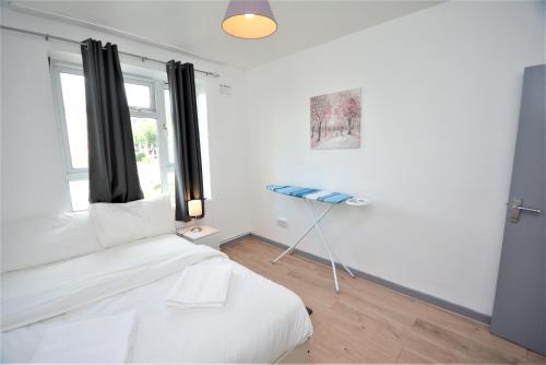伦敦Beautiful London 2 Bedroom Flat near Finsbury Park的白色的客房设有床和窗户。