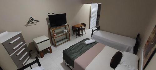 大普拉亚Pousada Zambeze的一间卧室配有一张床和一台平面电视