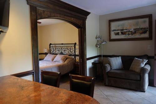 Centerport恰勒特宾馆及套房的一间卧室配有一张床、一张沙发和一面镜子