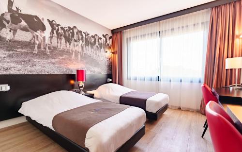 吕伐登巴斯通吕伐登酒店的酒店客房设有两张床,并装饰有一幅马画