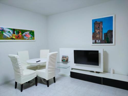 PolánCasa Rosales Toledo a 10 minutos de Puy du Fou的白色的客房配有桌椅和电视。