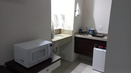 巴乌鲁Flat em Frente a USP - Centrinho - CPO - Medicina的一间配有微波炉和水槽的小浴室