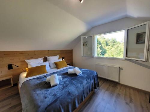 克松吕-隆日梅La cabane des écureuils的一间卧室配有一张带蓝色床单的大床和窗户。