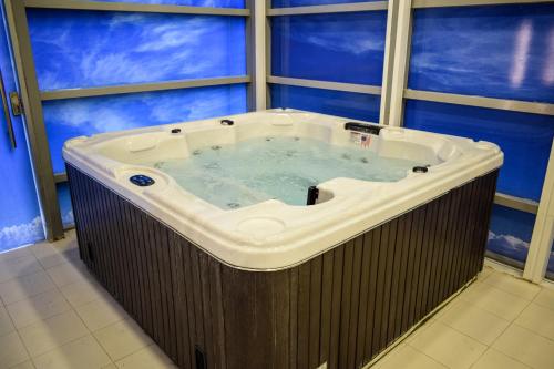 多哈萨拉亚滨海酒店 的带窗户的客房内的按摩浴缸
