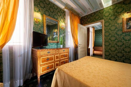 威尼斯圣塔马丽娜酒店的一间卧室配有一张床和一个带镜子的梳妆台