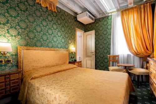 威尼斯圣塔马丽娜酒店的一间卧室配有床和绿色壁纸
