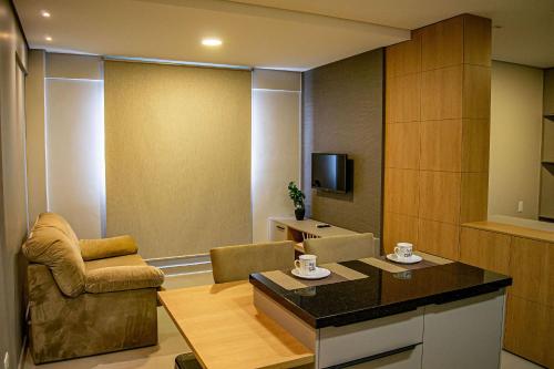 伊瓜苏NOVOS apartamentos STUDIO do ladinho do Paraguai的客厅配有沙发椅和电视