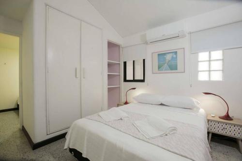 卡利Casa Mandala en Los Cristales的白色的卧室设有白色的床和窗户。