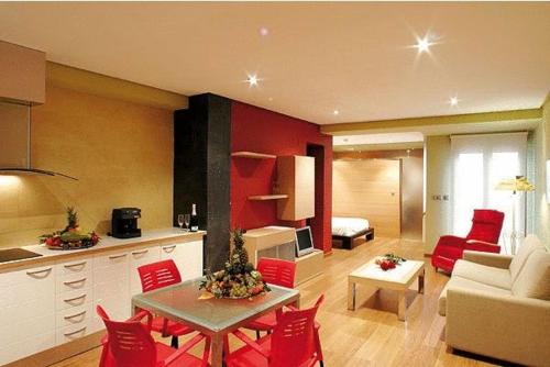 卡萨斯-伊瓦涅斯Hospedium Apartamentos Cañitas Maite Familiar的厨房以及带桌子和红色椅子的客厅。