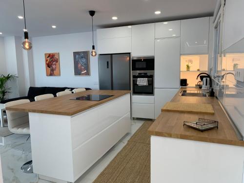 大加那利岛拉斯帕尔马斯Apartamento Casa Blanca的一间厨房,配有白色橱柜和厨房岛